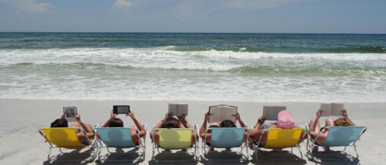 Reading at the beach slide with books and handheld devices